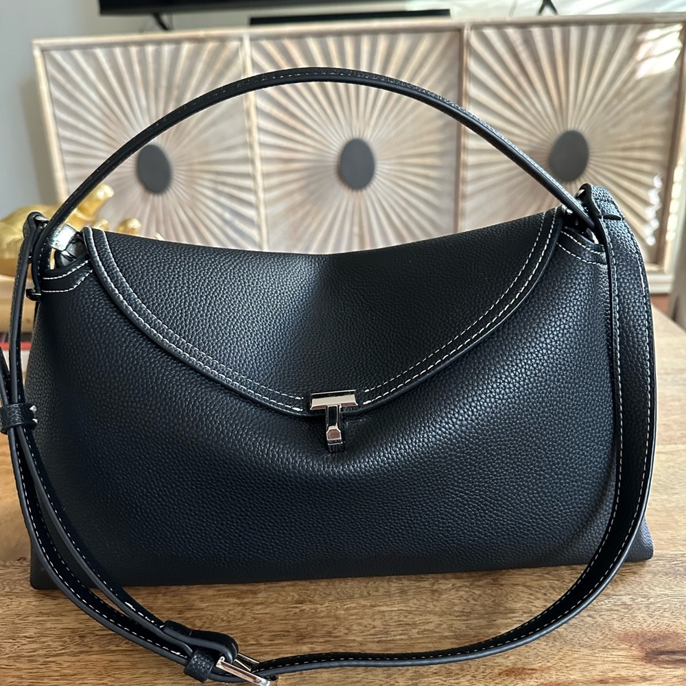 Black leather top handle shoulder bag in pebble grain.